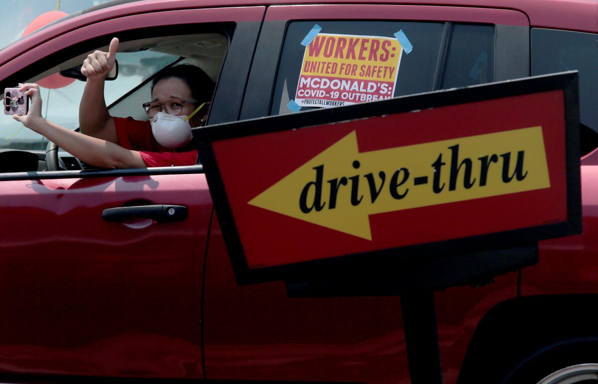 McDonald's cooks and cashiers hold a lunchtime drive-by rally outside the McDonald's restaurant in Boyle Heights 