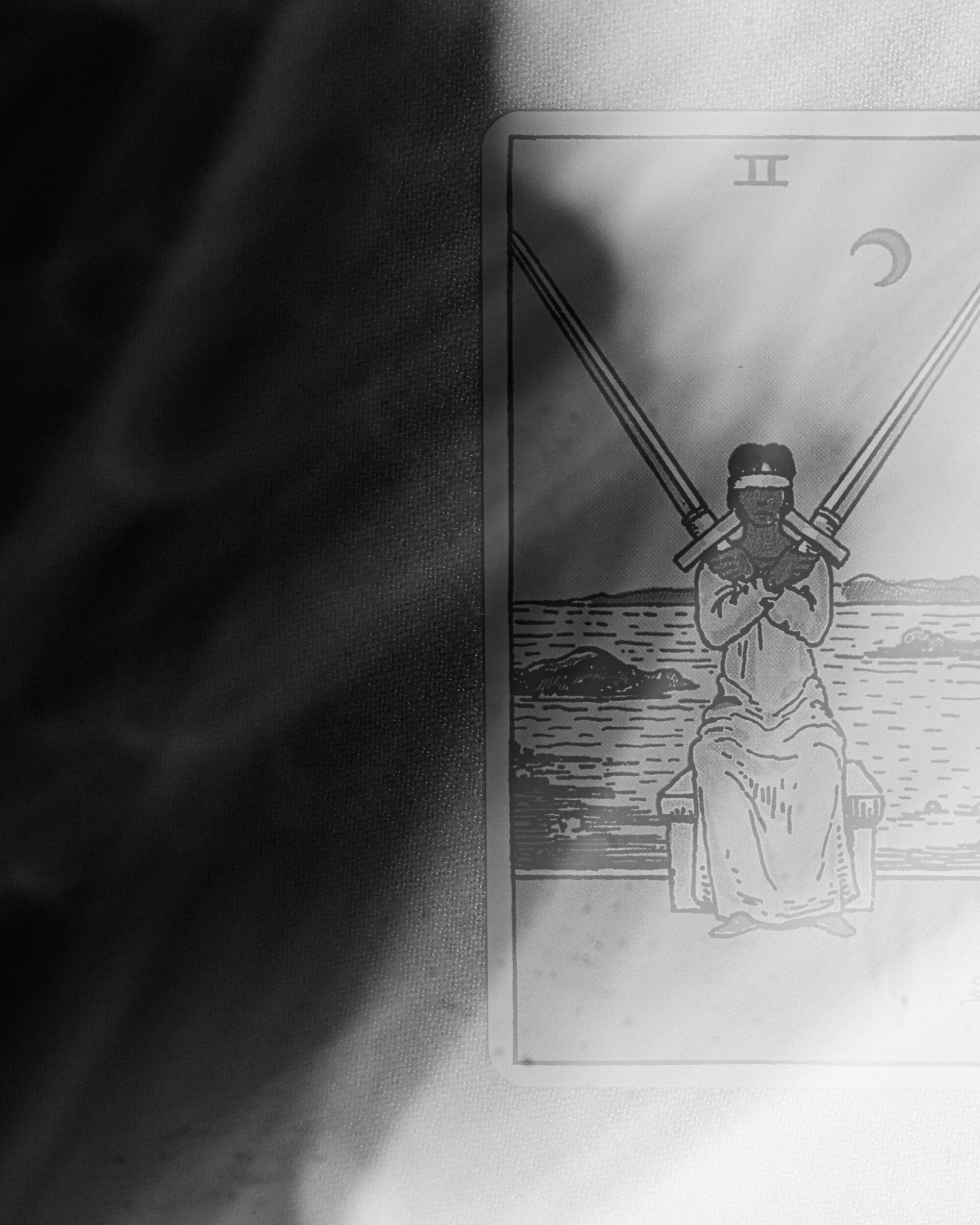 An illustration of someone holding swords on a tarot card 