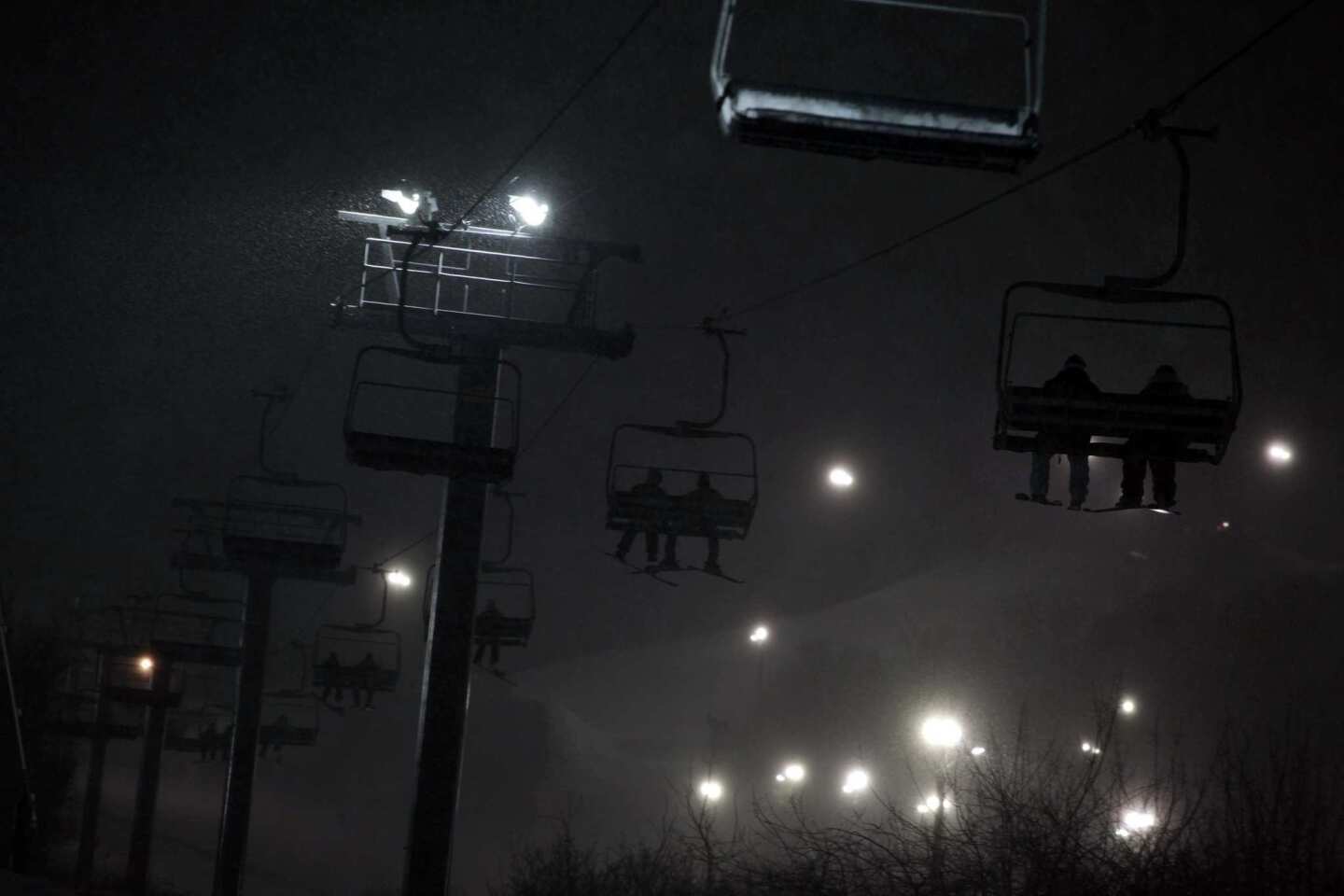 A few passengers ride the lifts during the snow storm.