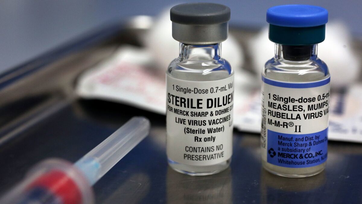 A vial containing the measles, mumps and rubella vaccine, right, and a vial containing the diluent used to mix the vaccine. The MMR vaccine is one of those required for day-care and school enrollment.