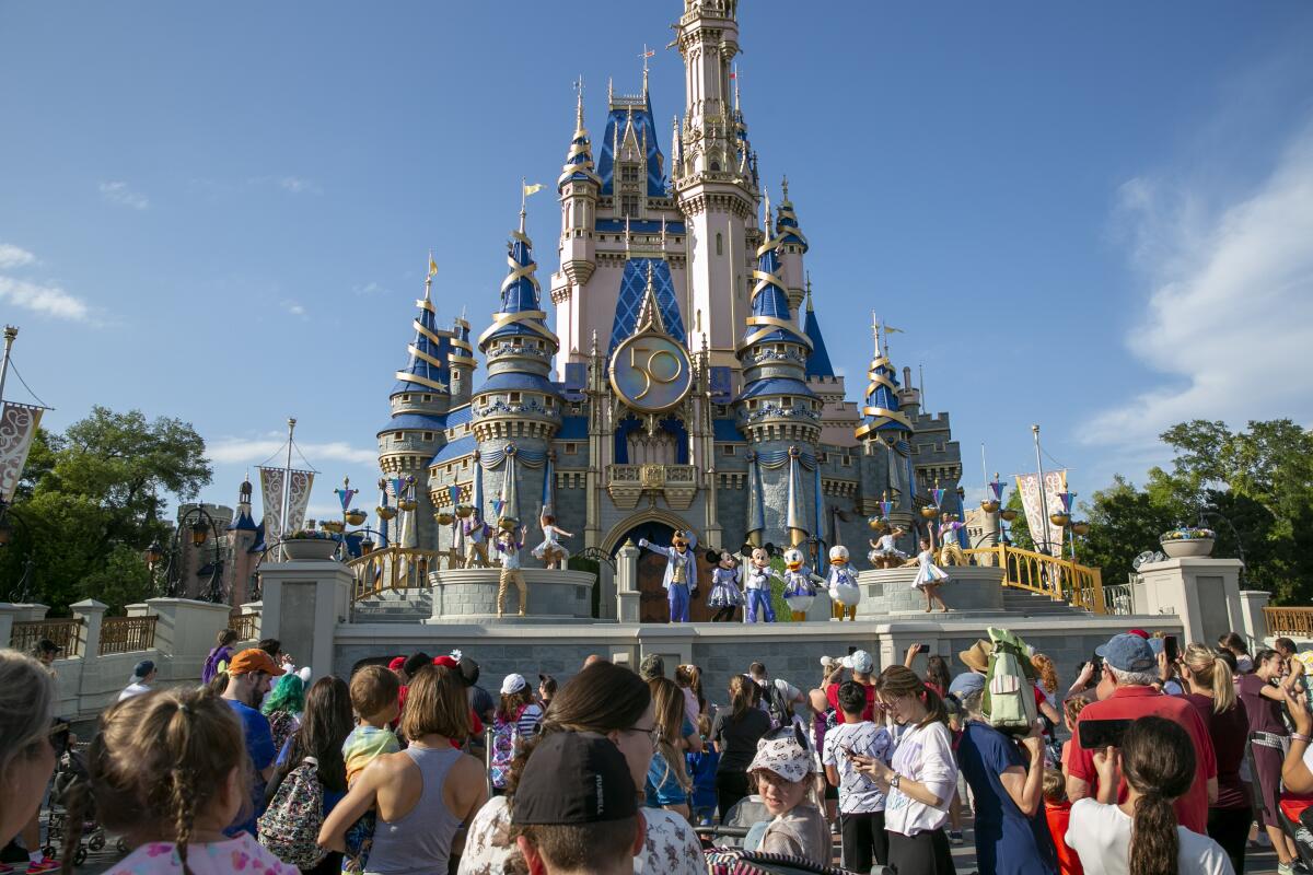 Performers and patrons stand in front of Cinderella Castle at Walt Disney World Resort in Florida.