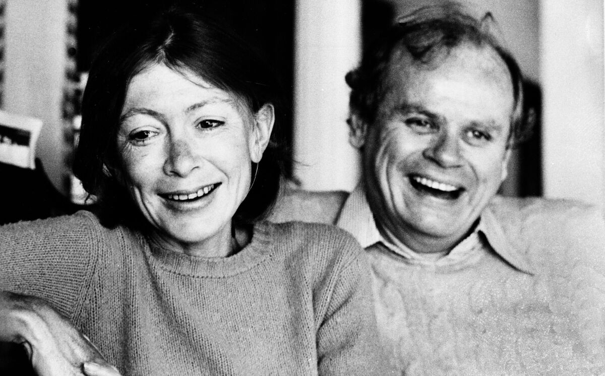 Joan Didion and  John Dunne, side by side, smile.