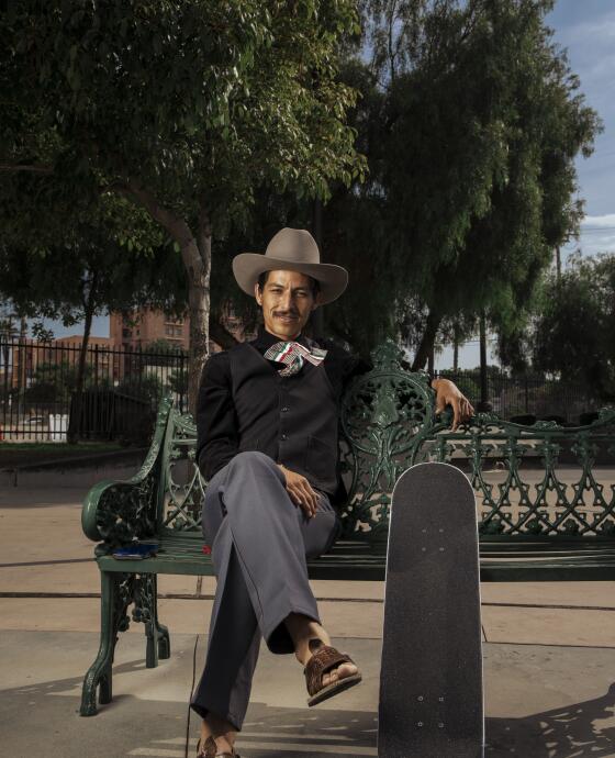 Steve Corona, 31, wears ranchero style clothing while sitting with his skateboard at Mariachi Plaza in Boyle Heights on Friday, September 23, 2023.