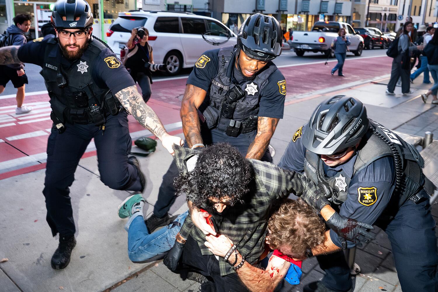 Police officers separate two men outside a Turning Point USA event at the University of California, Berkeley on Tuesday, Nov. 10, 2025, in Berkeley, Calif. (AP Photo/Noah Berger)