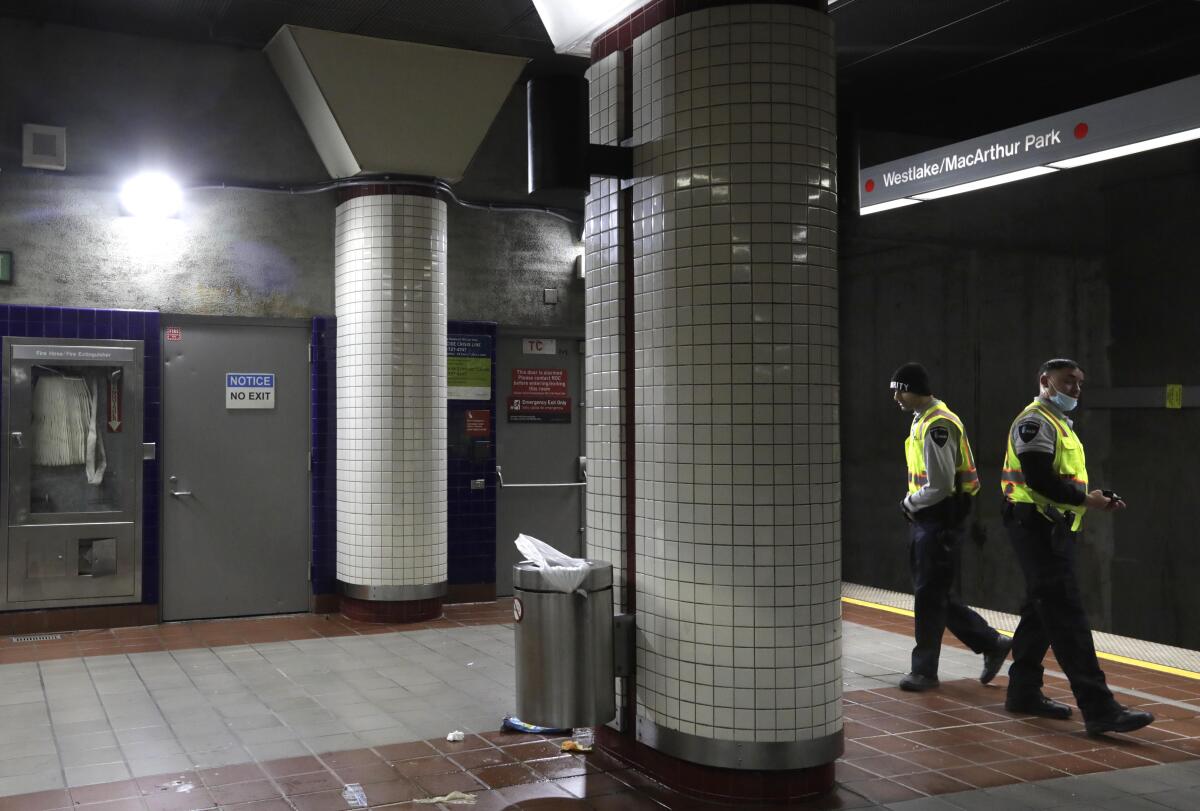Security guards patrol a subway station platform