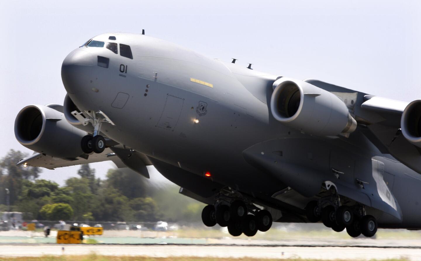 A Boeing C-17 Globemaster III takes off from Long Beach Airport en route to Hungary, part of the 12-nation Strategic Airlift. The Globemaster is designed for military and humanitarian airlifts.