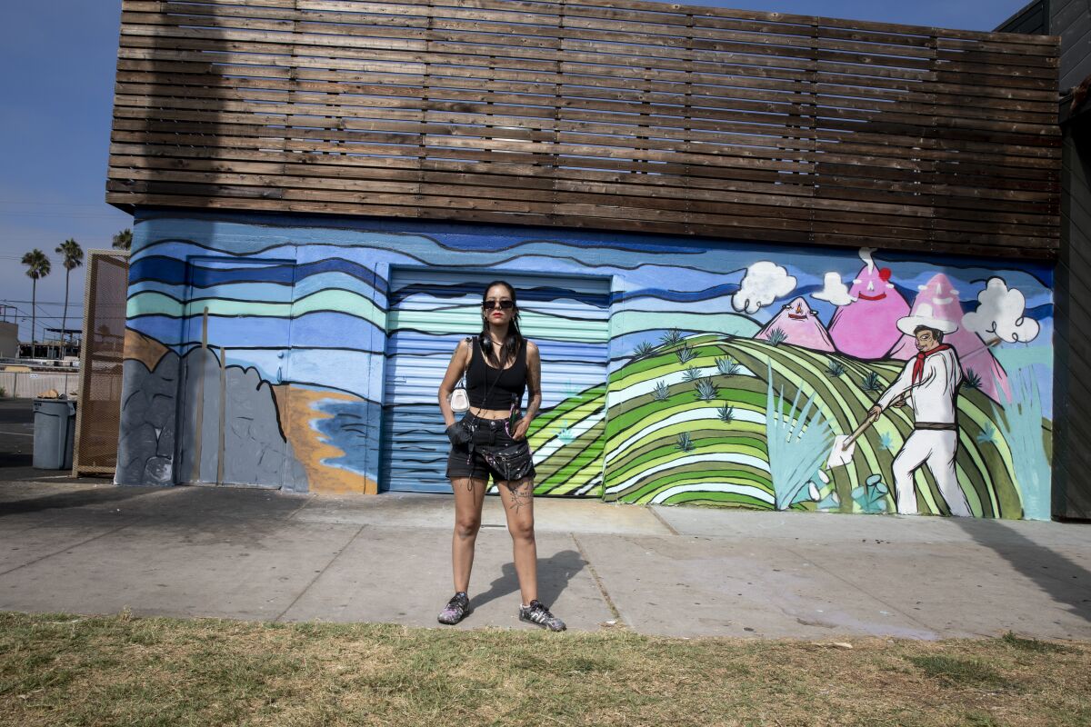 Paola Panca Villasenor frente a un mural inacabado llamado Mi Tierra fuera de La Doña en Ocean Beach 