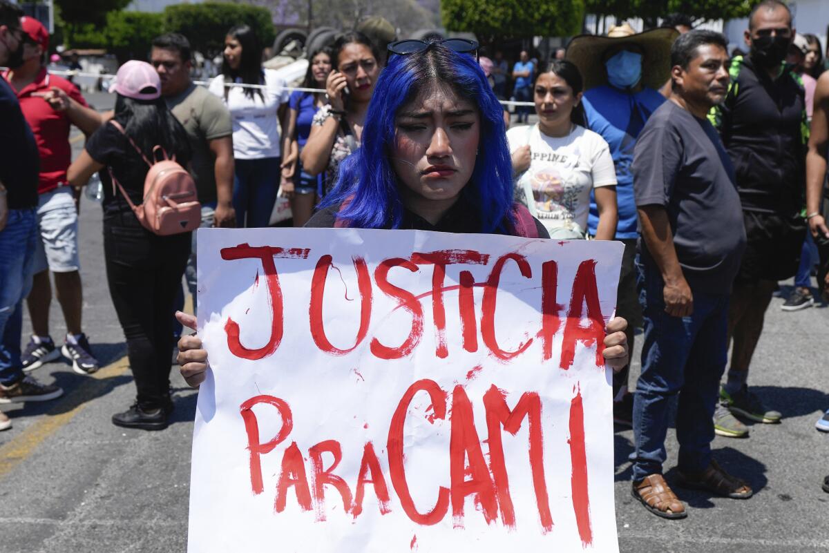 Una mujer con un cartel en el que pide justicia por la desaparición y muerte de una niña de 8 años 