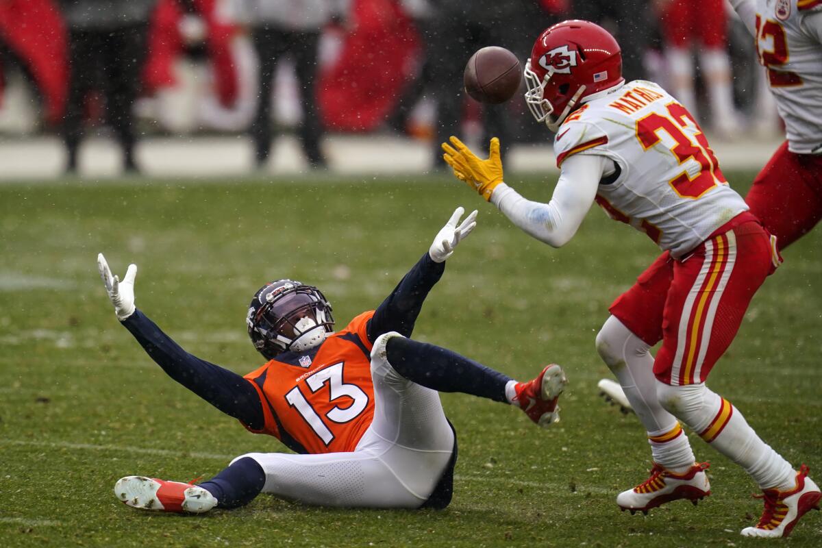 Denver Broncos wide receiver K.J. Hamler falls as Kansas City Chiefs strong safety Tyrann Mathieu intercepts a pass.