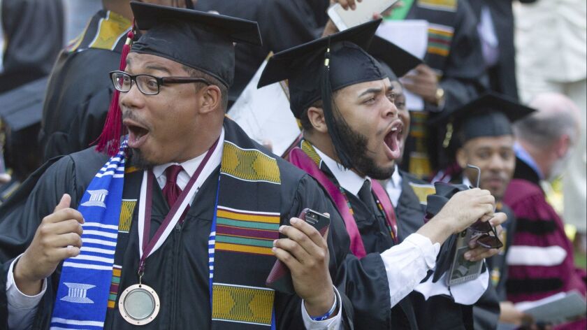 Graduates react after hearing billionaire technology investor Robert F. Smith say that he’ll provide grants to wipe out the student debt of the entire 2019 graduating class at Morehouse College in Atlanta.