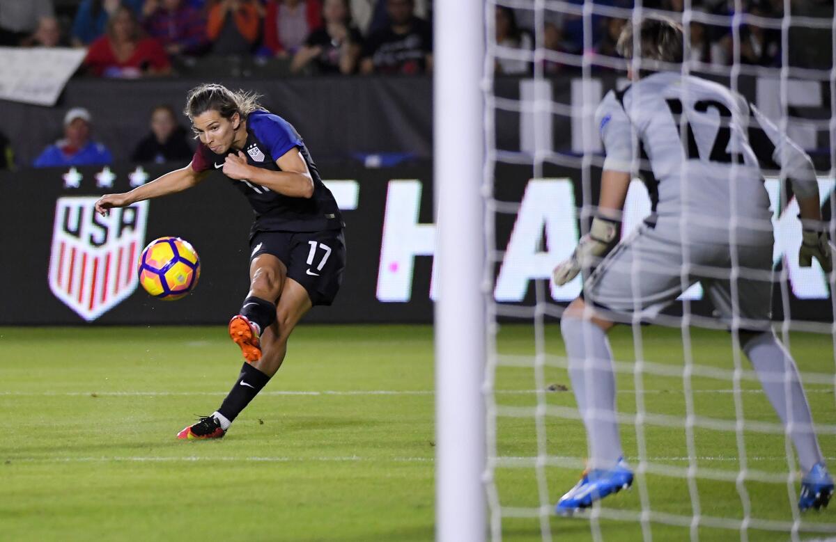 United States midfielder Tobin Heath, left, kicks toward the goal as Romania goalkeeper Roxana Oprea defends during the first half on Nov. 13.