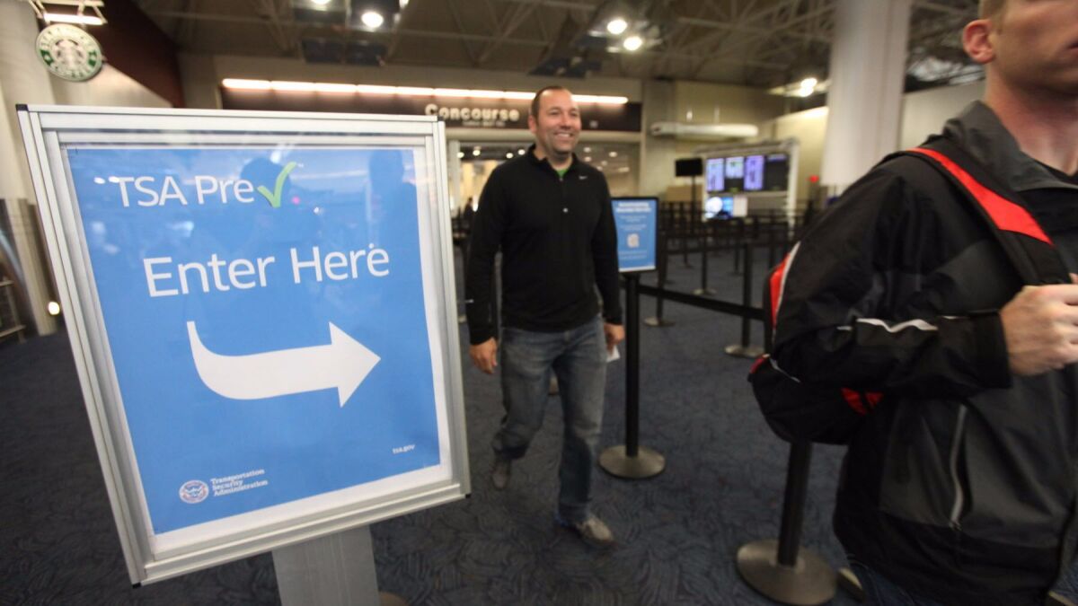 Passengers walk through the TSA PreCheck lane at Milwaukee's Mitchell International Airport. A survey of travelers found that nearly half of TSA PreCheck travelers say the lines are too long. (Mike De Sisti / Associated Press)