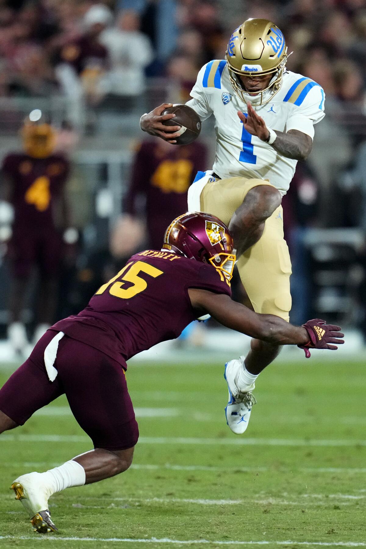 Bruins quarterback Dorian Thompson-Robinson leaps over Sun Devils defensive back Khoury Bethley on Nov. 5, 2022.