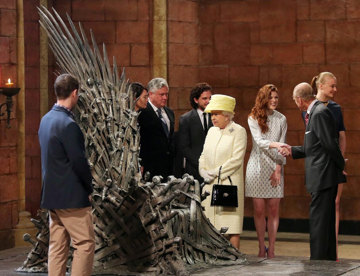 The queen meets cast members of the HBO TV series "Game of Thrones." Prince Philip, the duke of Edinburgh, shakes hands with Rose Leslie (Ygritte).