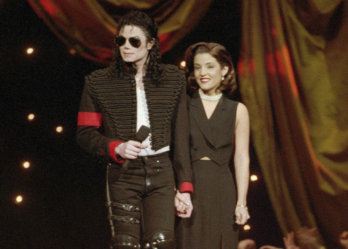 Michael Jackson holding hands with Lisa Marie Presley onstage at an awards show