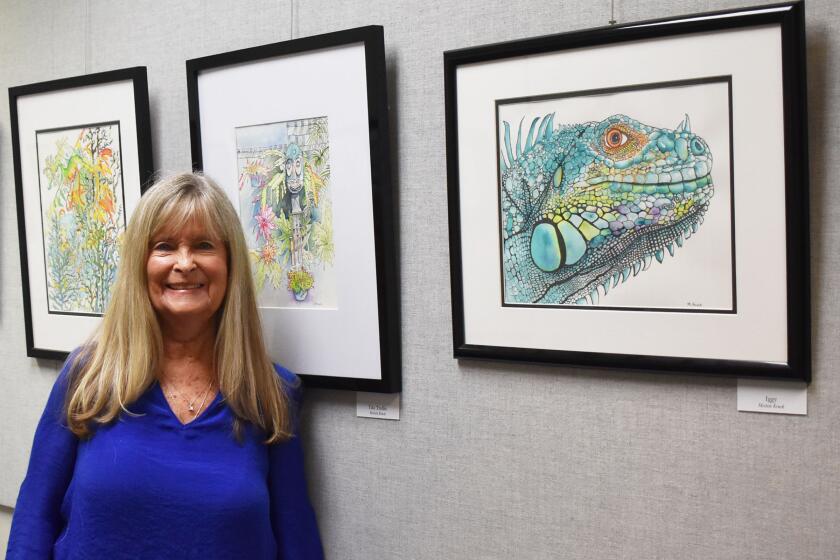 Michele Kruck next to some of her watercolor paintings on exhibit at the Rancho Bernardo Library. 