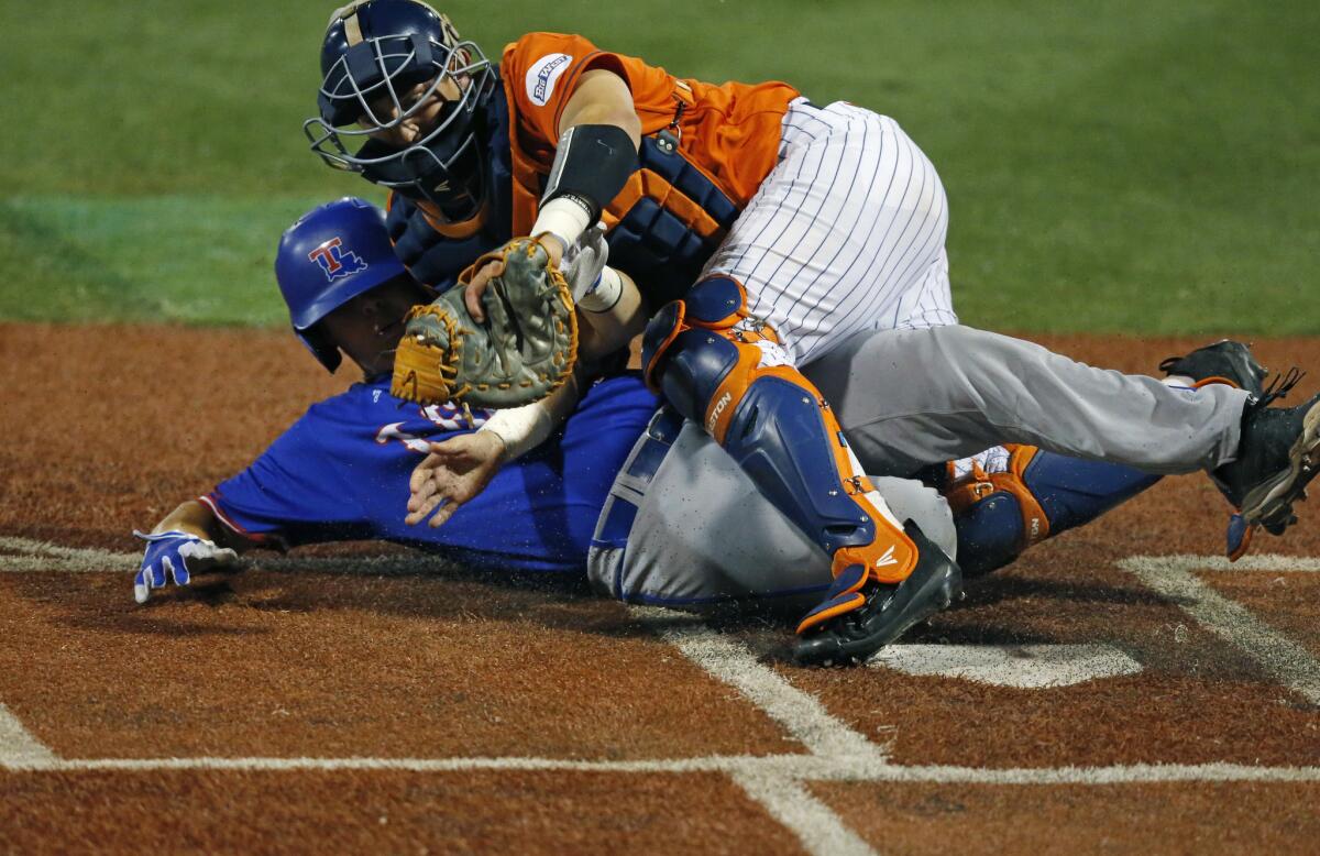 Louisiana Tech's Jonathan Washam is tagged out by Cal State Fullerton catcher Chris Hudgins while trying to steal home in the fourth inning Friday night.