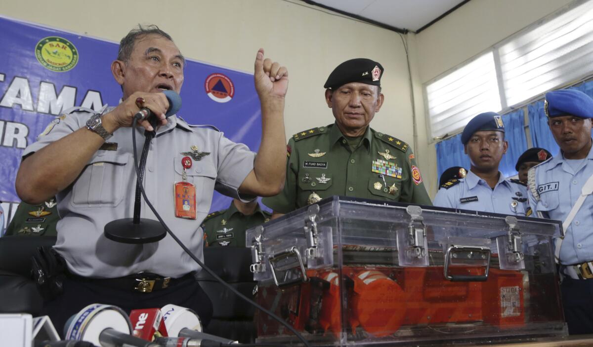 Tatang Kurniadi, left, chief of Indonesia's National Transport Safety Committee, speaks to the media at the airport in Pangkalan Bun on Jan. 12 as he displays the flight data recorder recovered from AirAsia Flight 8501.