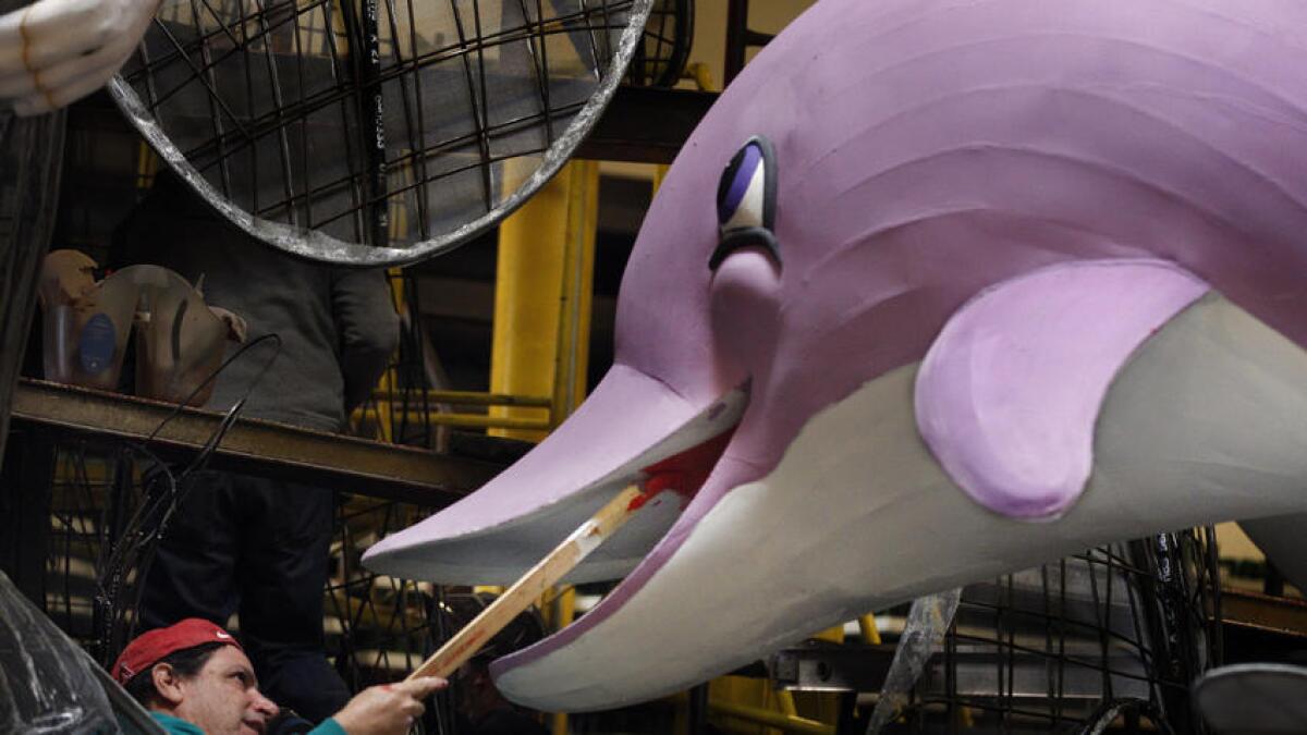 Artist Marcus Pollitz readies a dolphin on a float for the 128th Rose Parade, which moved to to Monday instead of New Year's Day, which fell on a Sunday.
