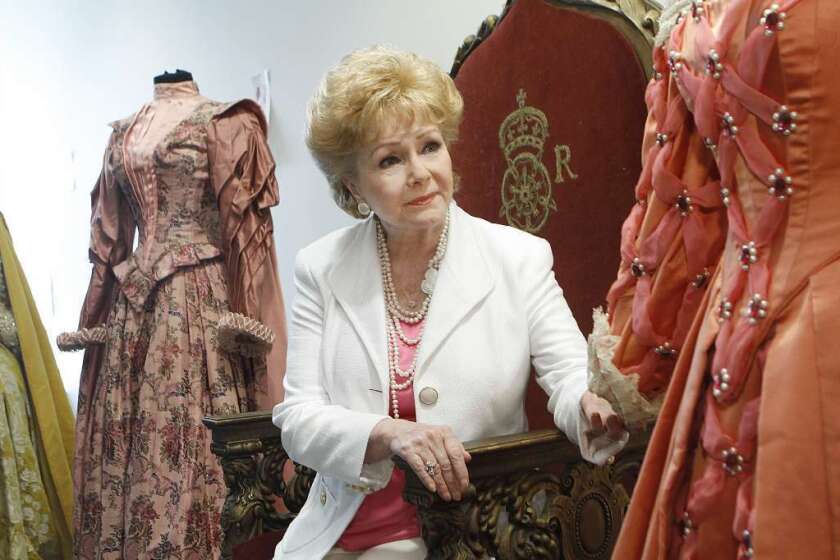 Debbie Reynolds sits on the throne from the 1955 movie "The Virgin Queen" in 2011, before an auction of items in her collection of memorabilia from classic movies.