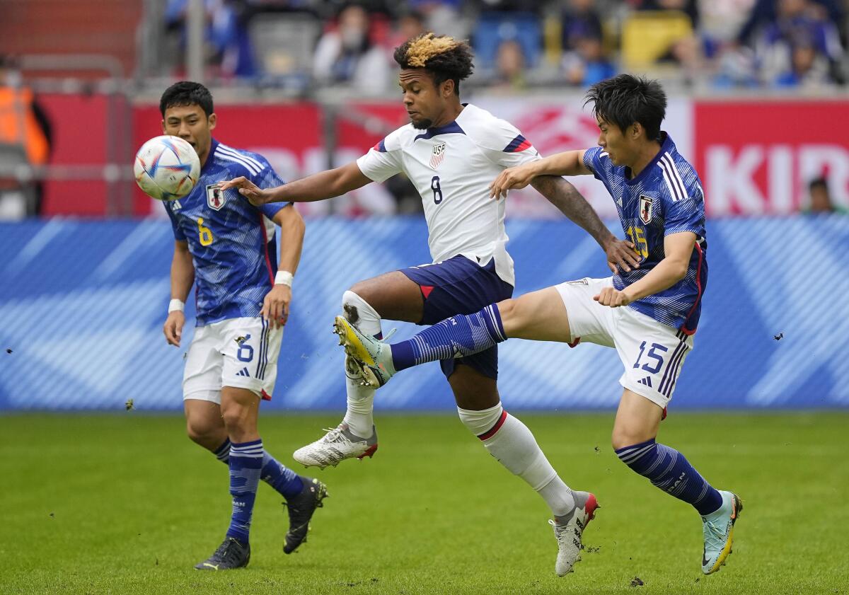 Japan's Daichi Kamada, right, and Weston McKennie challenge for the ball.