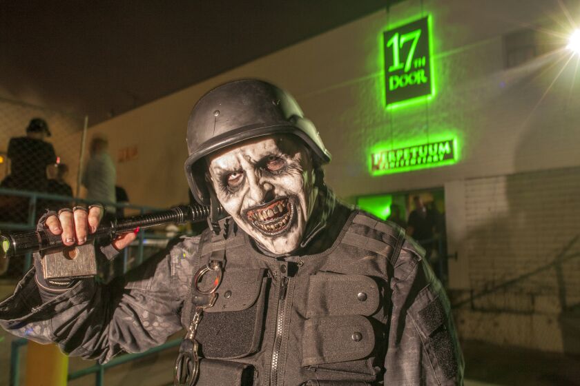 Waving a cattle prod, the Main Guard inducts visitors into the 17th Door Haunted Experience in Fullerton.