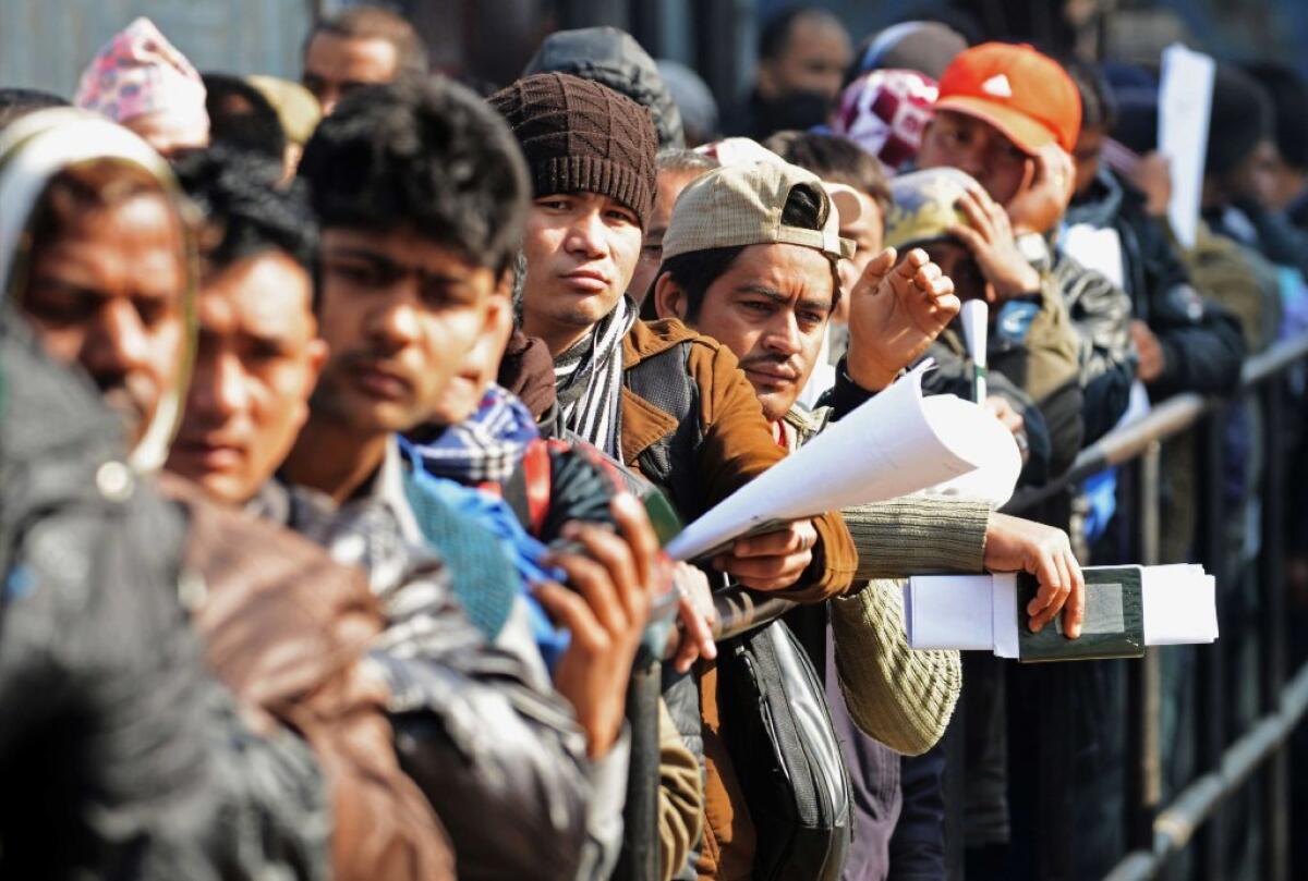Nepali migrant workers last month queue to receive official documents in order to leave Nepal. Nearly 200 Nepali migrant workers died in Qatar in 2013, many of them from heart failure, officials said, figures that highlight the grim plight of laborers in the Gulf nation.