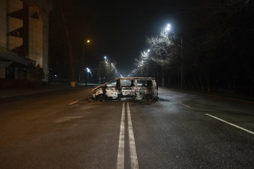 A police bus, which was burned after clashes, remains in an empty street in Almaty, Kazakhstan, late Saturday, Jan. 8, 2022. The office of Kazakhstan's president says about 5,800 people were detained by police during protests that burst into violence last week and prompted a Russia-led military alliance to send troops to the country. (AP Photo/Vasily Krestyaninov)