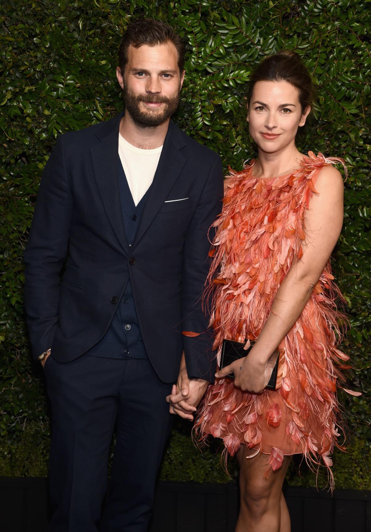 Jamie Dornan, left, and Amelia Warner attend the Charles Finch and Chanel pre-Oscars dinner.