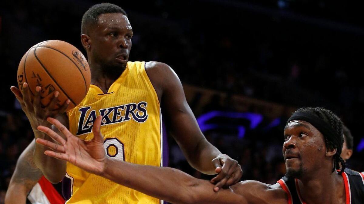 Lakers forward Luol Deng grabs a rebound in front of Trail Blazers forward Noah Vonleh during a preseason game on Oct. 11.