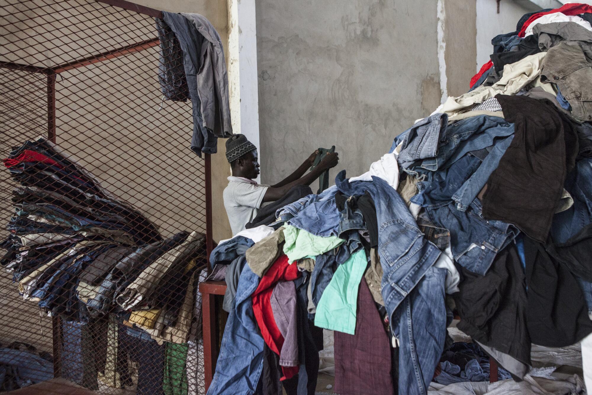 A person sorts a pile of clothes.