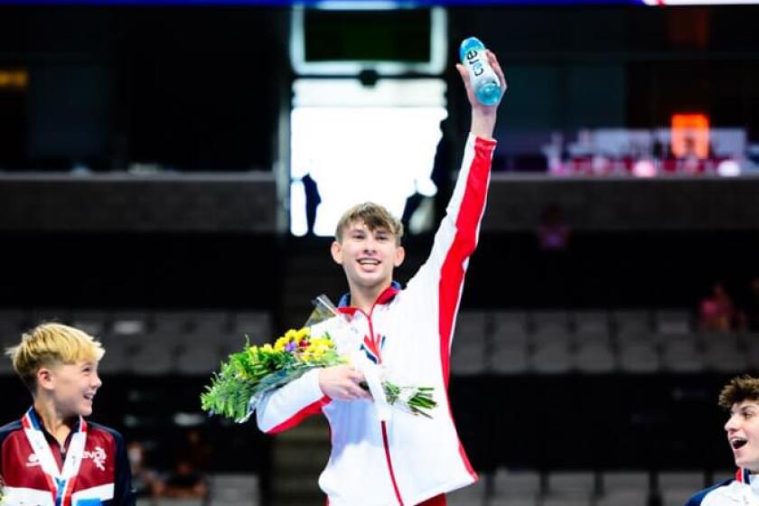 Nathan Roman, center, won the Junior Men’s 16-year-old National Title at the 2023 Xfinity U.S. Gymnastics Championships.
