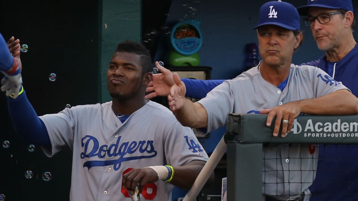 Dodgers right fielder Yasiel Puig and Manager Don Mattingly congratulate Matt Kemp (not pictured) on his home run against the Kansas City Royals on June 25.