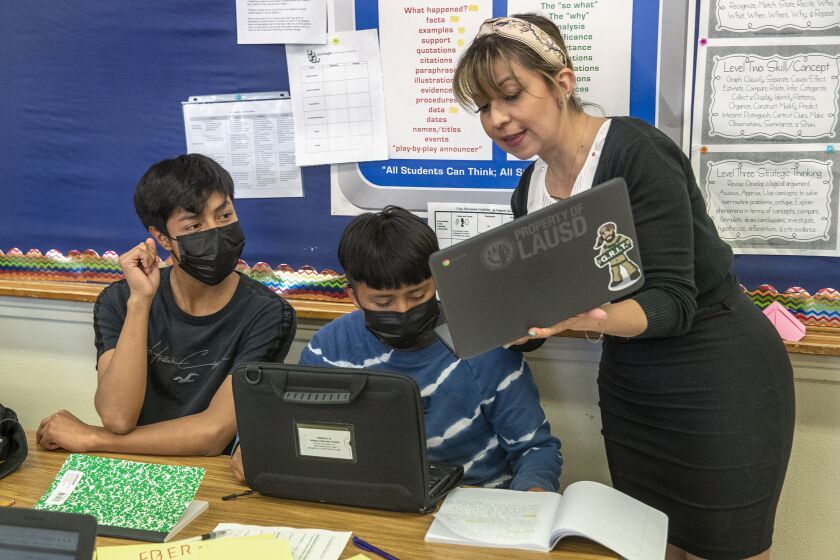 CANOGA PARK, CA-JUNE 24, 2022: Instructor Karen Gonzalez Aglugub helps a student, during an international newcomer enrichment summer program at Canoga Park High School for new students to our country to gain language acquisition. (Mel Melcon / Los Angeles Times)