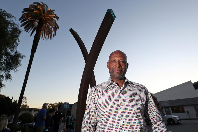 Local sculptor Gerald Stripling with his public art piece "Anastasis" during unveiling ceremony at the Laguna Beach City Hall Lawn on Wednesday.