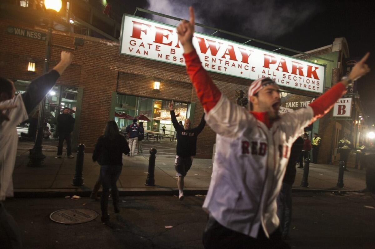 Fans rush out of Fenway Park after the Red Sox won the World Series in Boston on Wednesday.