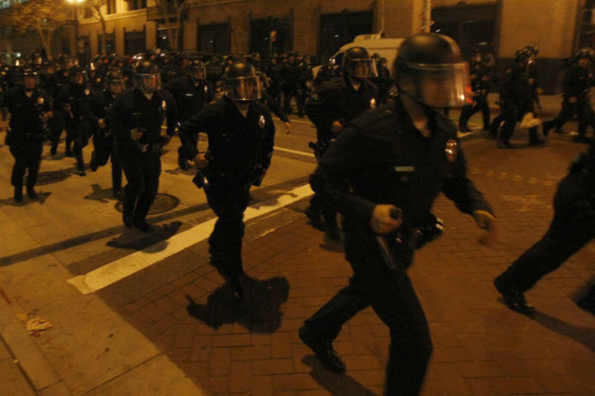 In this image from November 2011, LAPD officers rush down Spring Street in a show of force during the Occupy L.A. protests.