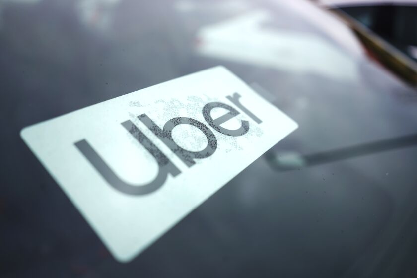 FILE - An Uber sign is displayed inside a car in Palatine, Ill., United States, Feb. 10, 2022. Uber had agreed to pay a 26 million Australian dollar ($19 million) fine for misleading riders by falsely warning they could be charged a cancellation fee and for inflating estimates of what a taxi would cost for the same journey, Australia’s consumer watchdog said on Tuesday, April 26, 2022. (AP Photo/Nam Y. Huh, File)