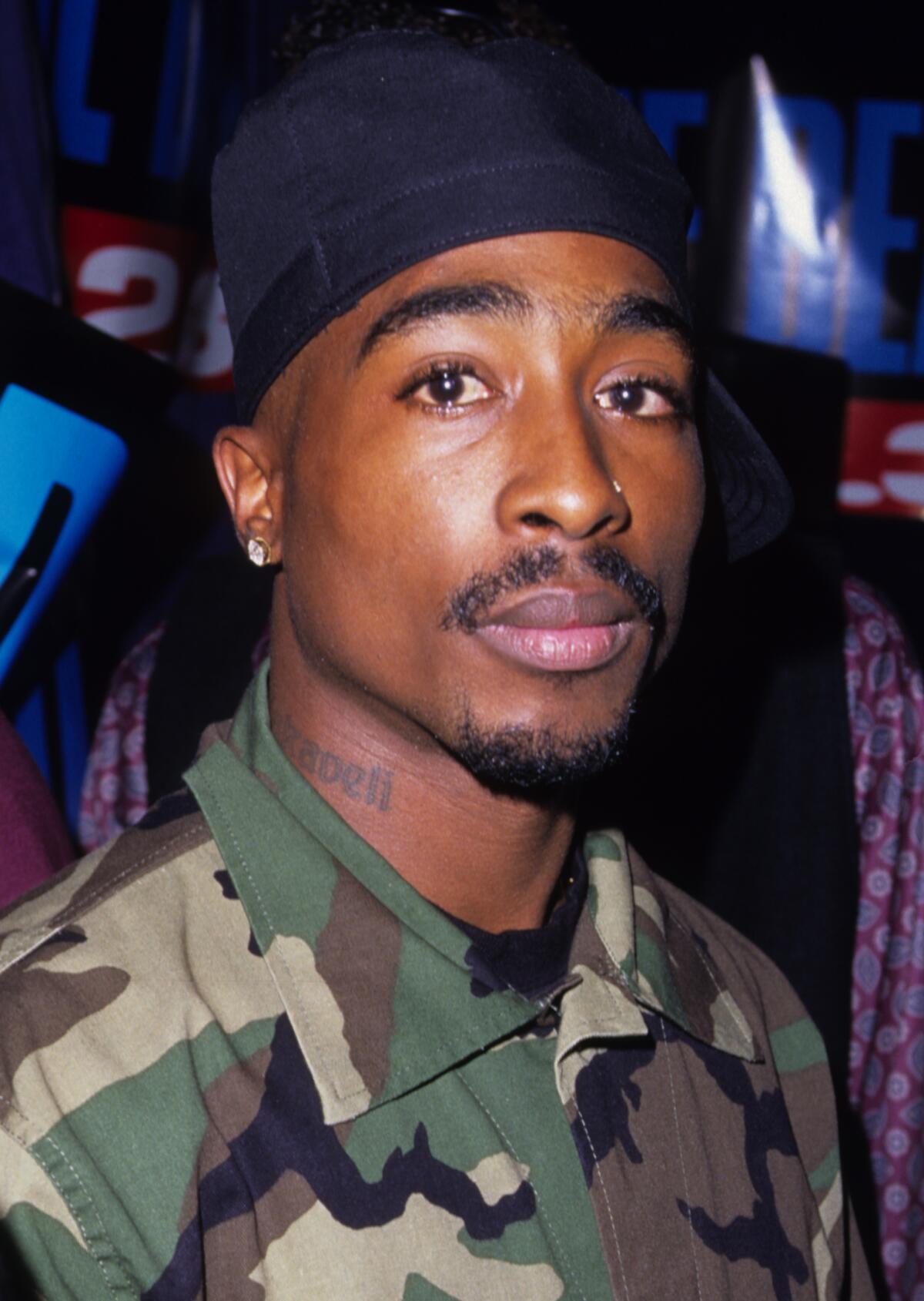 Tupac Shakur in a head-and-shoulders vertical frame, looking at the camera in a relaxed yet direct way