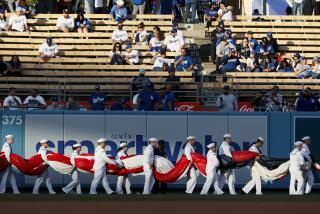 Los Angeles, CA - April 14: Servicemen carry a large American flat onto the field before the game against the Cincinnati Reds at Dodger Stadium on Thursday, April 14, 2022 in Los Angeles, CA.(Robert Gauthier / Los Angeles Times)