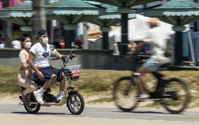 Masked and mobile, cyclists make their way along the bicycle path in Venice Beach.