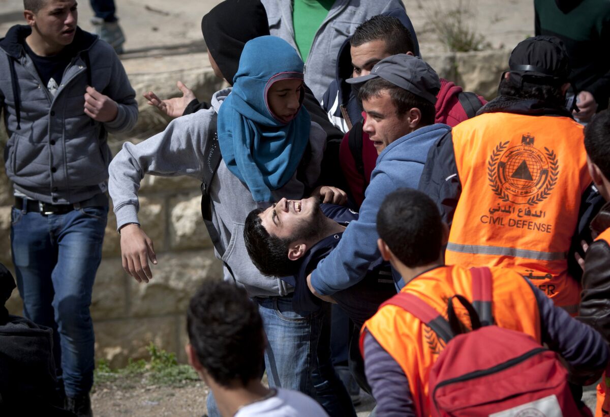 Palestinians carry an injured man during an operation by Israeli troops in the West Bank town of Bir Zeit on Feb. 27, 2014.