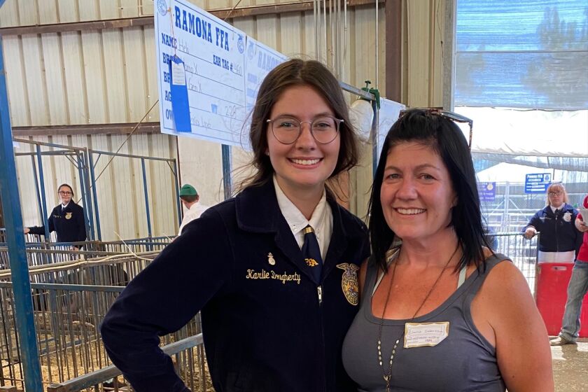 Karlie Dougherty, of Ramona FFA, with mom Jamie Severtson after the record-breaking bid for her pig, Kate Dutton.  