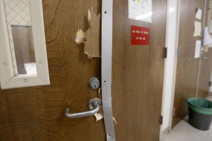 Smashed doors can be seen on the fourth floor of the UCLA engineering building where Wednesday's murder-suicide took place.