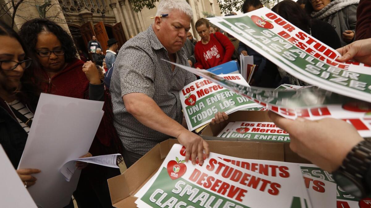 Members of United Teachers Los Angeles pick up signs and other materials Saturday for a possible upcoming strike after a meeting at the Immanuel Presbyterian Church in Los Angeles.