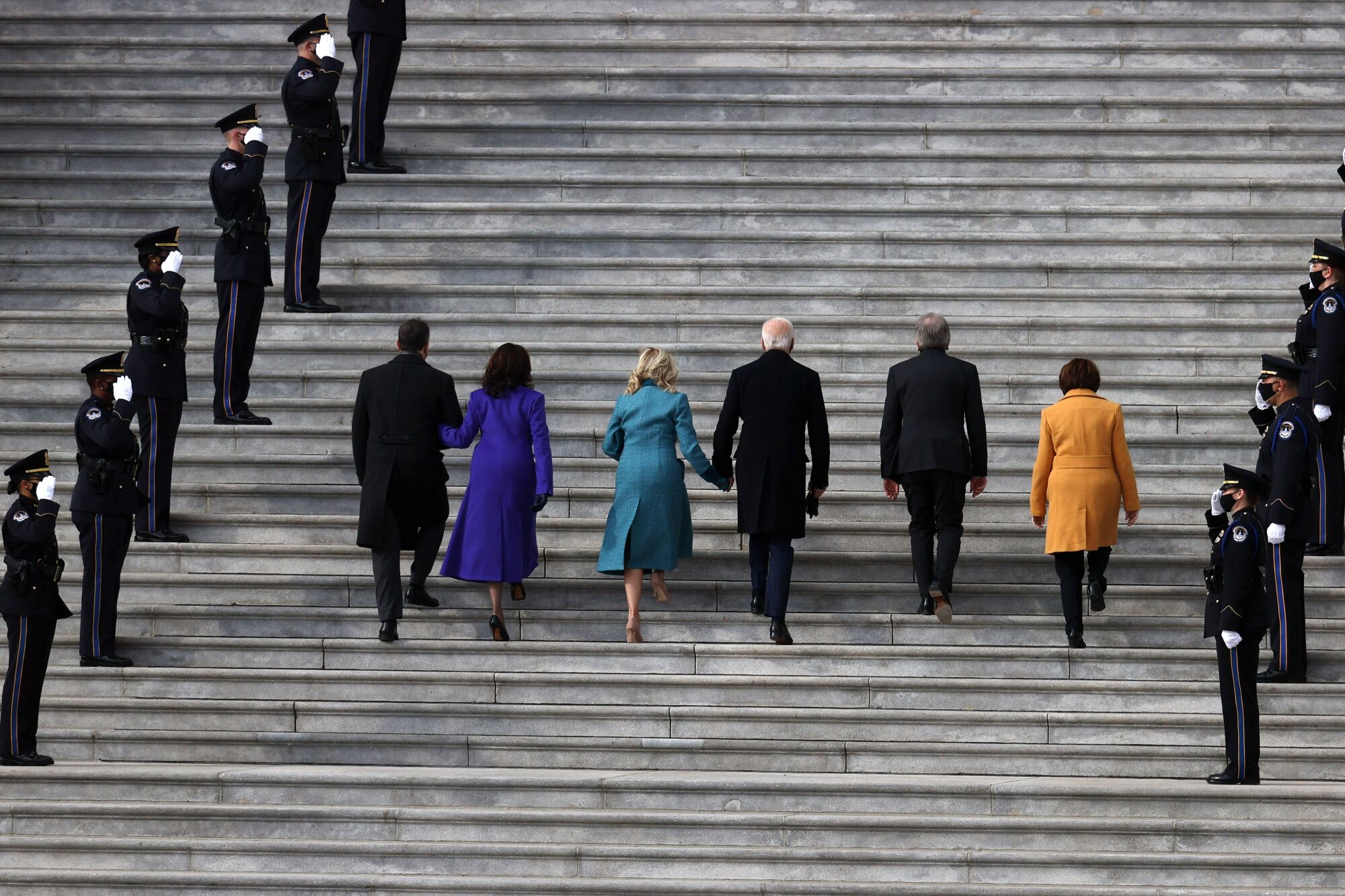 Kamala Harris, Joe Biden and their spouses, joined by two senators, walk into the Capitol for the inauguration.