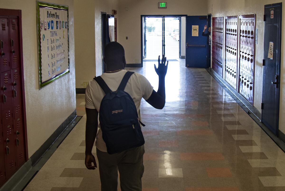 Damion Lester Jr. waves to a teacher as he leaves school for the day at Washington Prep High School in Los Angeles.