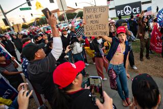 BEVERLY HILLS, CA - NOVEMBER 07: A Trump supporter dances at a rally in Beverly Hills as Joe Biden is elected president on Saturday, Nov. 7, 2020 in Beverly Hills, CA. (Jason Armond / Los Angeles Times)