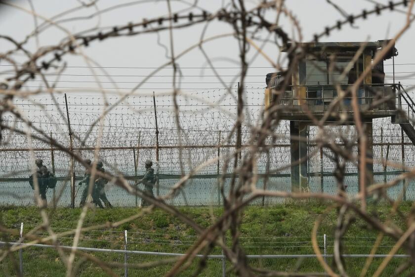 South Korean army soldiers pass by the barbed-wire fence in Paju, South Korea, near the border with North Korea, Friday, April 19, 2024. (AP Photo/Ahn Young-joon)