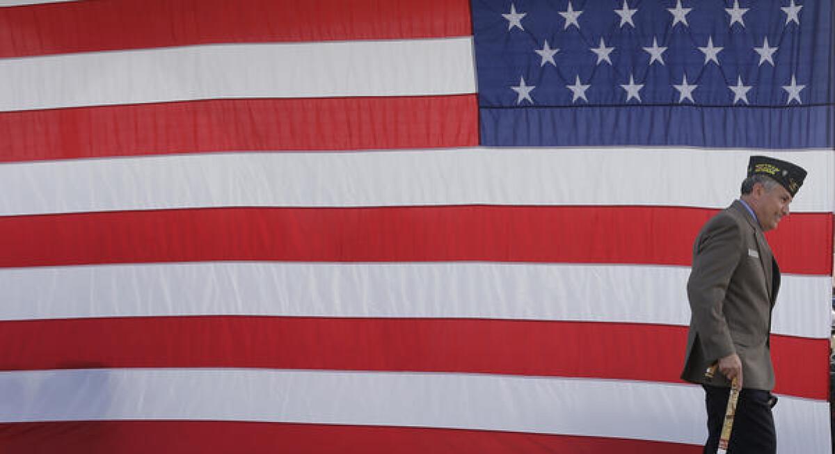 A veteran passes a U.S. flag during a Veterans Day ceremony at Fort Sam Houston National Cemetery in San Antonio.